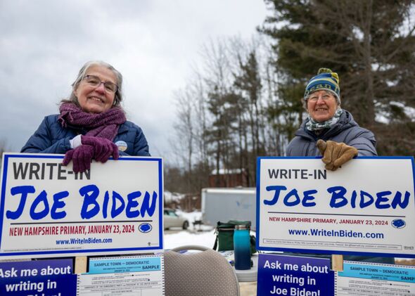 Supporters of President Joe Biden greet voters in Loudon, New Hampshire