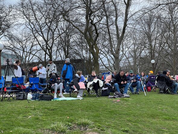 Eclipse viewers sit on the grass at Niagara Falls