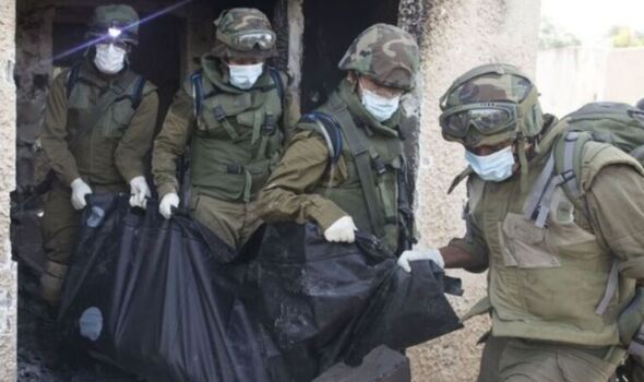 Israeli soldiers remove the body of civilian in Kfar Aza.
