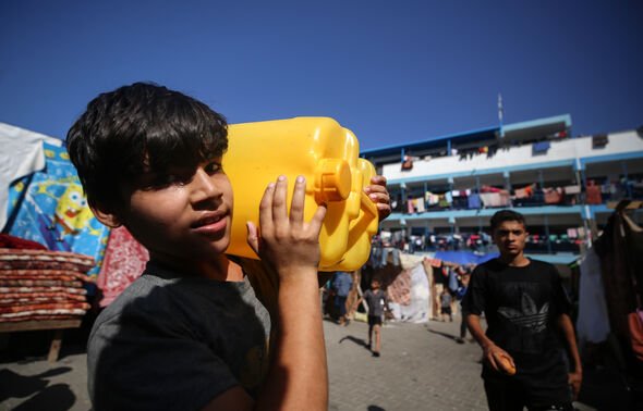 Displaced people are seen in the yard of a UNRWA school.