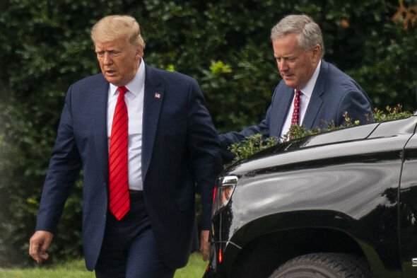 President Donald Trump talks to White House chief of staff Mark Meadows, right